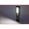 Een zwarte LED-werklamp schijnt fel. Hij staat op een schuin oppervlak. Een witte lichtkegel wordt op een grijze ondergrond geworpen.